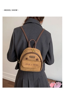Rear view of a model wearing a brown suede cat-themed mini backpack with cute ears
