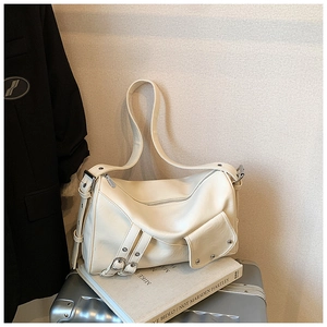 Vue détaillée du sac fourre-tout ivoire avec boucles métalliques et rivets sur valise