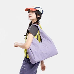 Shoulder view of a large lavender tote bag with pleated texture on a female model