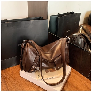 Détail du sac cabas en cuir marron foncé avec boucles métalliques et larges bandoulières