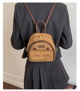 Close-up of cat-ear design on vintage brown leopard pattern mini backpack with gold zippers