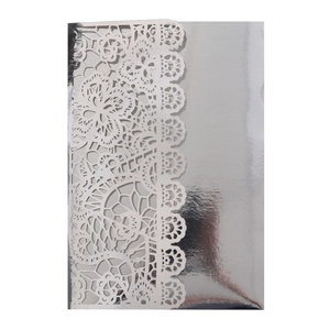 Detail of silver laser-cut wedding invitation with intricate lace floral patterns