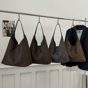 Close-up van hobo tote bags in vier luipaardprints hangend aan een rekje