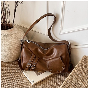 Détail d'un sac cabas vintage en cuir marron avec fermetures éclair et boucles argentées
