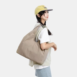 Detail view of khaki nylon tote bag featuring durable wide straps and a minimalist design