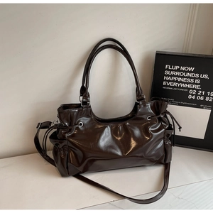 Détail du sac en cuir marron foncé brillant avec poches latérales et design à cordon