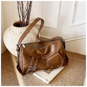 Gros plan sur le sac fourre-tout marron vintage avec similicuir et boucles argentées
