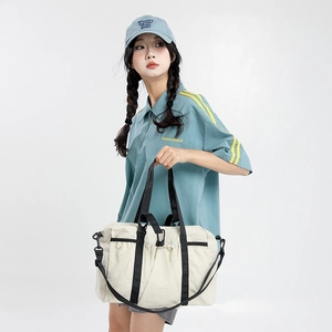 Detailed macro view of the cream white travel tote bag showing soft texture and side pocket