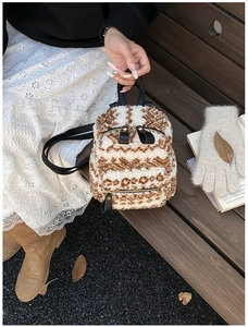 Detailansicht eines Mini-Plüschrucksacks mit Tiermuster auf einer rustikalen Holzbank