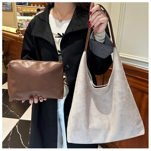 Detail view of large grey suede hobo bag paired with a brown faux leather inner pouch