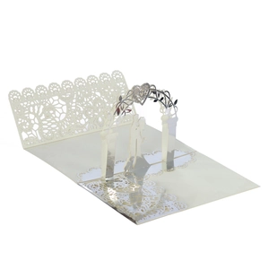 Macro detail of laser-cut lace wedding invitation with 3D pop-up arch and couple silhouette