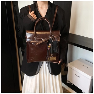 Détails du sac à dos en cuir ciré marron foncé montrant la texture brillante et les perles
