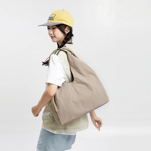 Detail view of khaki nylon tote bag with pleated texture and wide shoulder strap