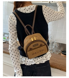 Detail showing back view of vintage leopard-print cat-shaped mini backpack on model
