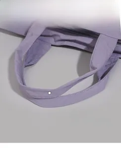 Detail of comfortable purple nylon tote bag handle with reinforced stitching and soft fabric