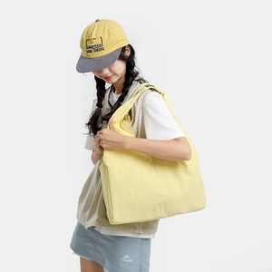 Detail view of a large yellow shoulder tote bag in light canvas for casual daily use