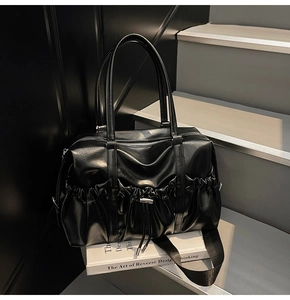 Détail du sac cabas plissé noir montrant la texture PU brillante et le cordon de serrage
