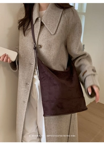 Deep chocolate suede bucket bag shown worn over a beige cashmere coat for daily commute