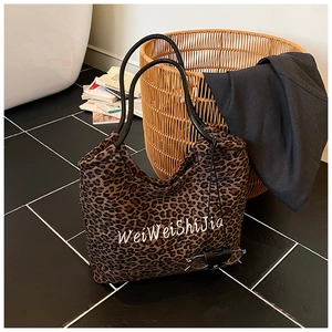Top view of spacious leopard print tote bag with black handles and embroidered detail