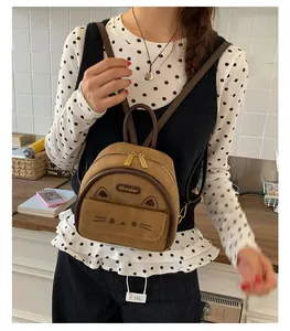 Detail of brown faux suede mini backpack with 3D cat ears and embroidered kitten face