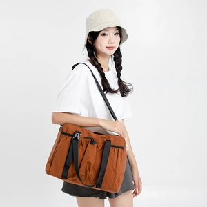 Detail view of khaki crossbody bag with black buckle closure and adjustable nylon straps