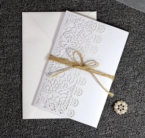 Detailed set of laser cut lace wedding invitation with pearl brooch and hemp rope