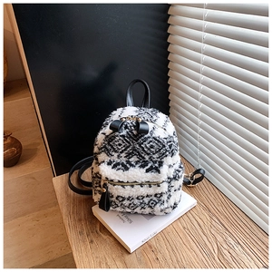 Detail eines Plüsch-Mini-Rucksacks mit schwarz-weißem Muster und goldenem Reißverschluss