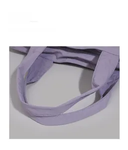 Close-up of soft purple tote bag handles showing reinforced stitching and durable fabric