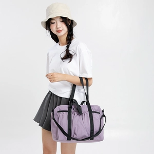 Large purple travel tote bag with nylon texture and black straps shown on a model