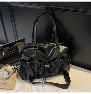 Détail du sac cabas en similicuir noir brillant avec poche à cordon et large bandoulière