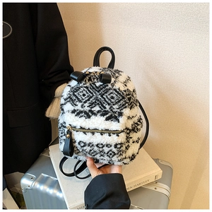 Detail eines Plüsch-Mini-Rucksacks mit schwarz-weißen Mustern und schickem Schleifenakzent