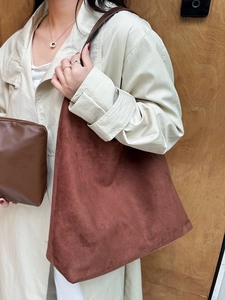 Brown suede tote bag with matching leather pouch worn with a beige trench coat