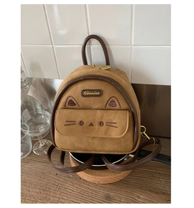 Detail of a brown mini cat-themed backpack with embroidered cat ears and whiskers