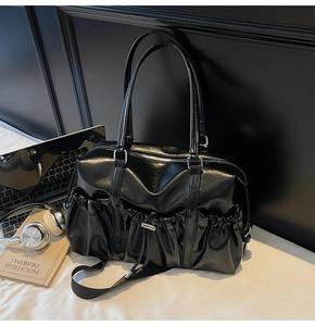 Détail d'un cabas vintage en cuir huilé noir avec poche plissée à cordon et garnitures argentées