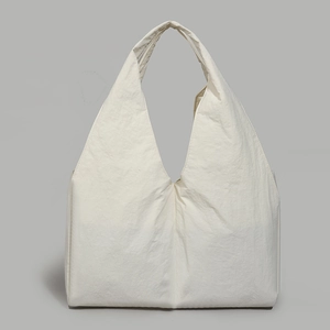Detail view of large white tote bag featuring pleated nylon fabric and deep V-shaped top