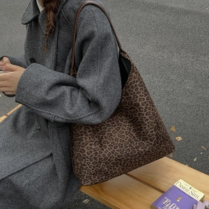 Lifestyle-opname van een ruime tote bag met luipaardprint op een houten parkbank