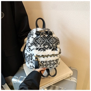 Detail eines Mini-Plüschrucksacks mit schwarz-weißem Jacquard-Muster und Ledergriff