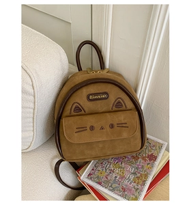 Detail of a brown cat-themed mini backpack with 3D ears and soft suede texture
