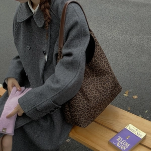 Detailweergave van de vintage leopard tote bag met bruine leren schouderriem op model