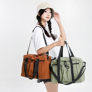 Detail of travel tote bags showing brown and green nylon fabric with drawstring pockets