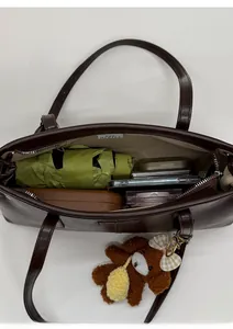 Top view of spacious interior of brown PU leather tote bag with a zipper and items