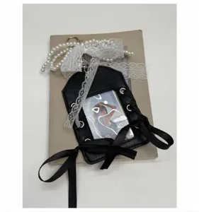 Dettaglio porta carte in PU nero vintage con fiocco in pizzo e catena di perle