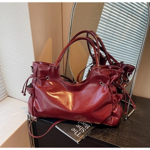 Détail du sac cabas en cuir verni bordeaux avec cordon et poche latérale