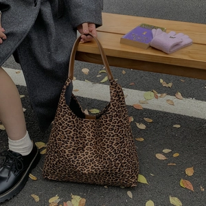 Detail van de tote bag met luipaardprint en leren riemen in een herfstachtige straatsetting