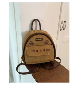 Detail of cute cat-shaped backpack with 3D ears and embroidered whiskers in khaki suede