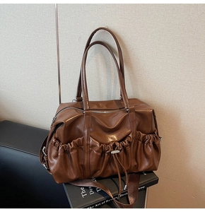 Vue détaillée du grand sac Boston marron foncé avec cordon de serrage et boucles