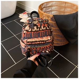 Details der bunten Strickstruktur des Mini-Rucksacks mit schwarzen Lederriemen