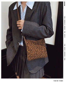 Dettaglio della borsa a tracolla leopardata con cinturino in pelle marrone su modella