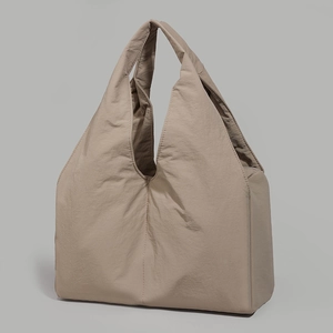 Detail of taupe oversized tote bag featuring lightweight crinkled fabric and wide handle