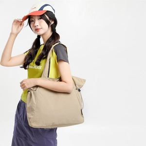 Detail of beige nylon tote bag with black drawstring closure for casual outdoor styling